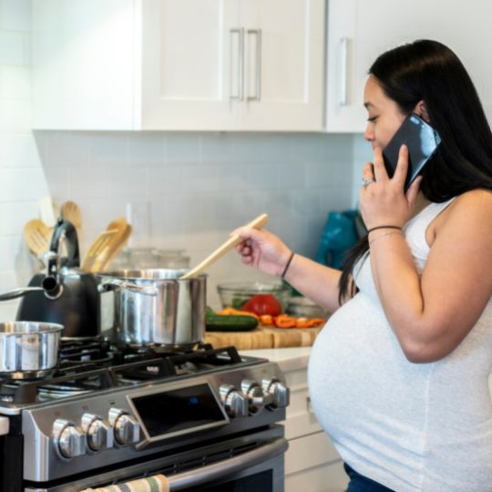 Pregnant woman cooking.