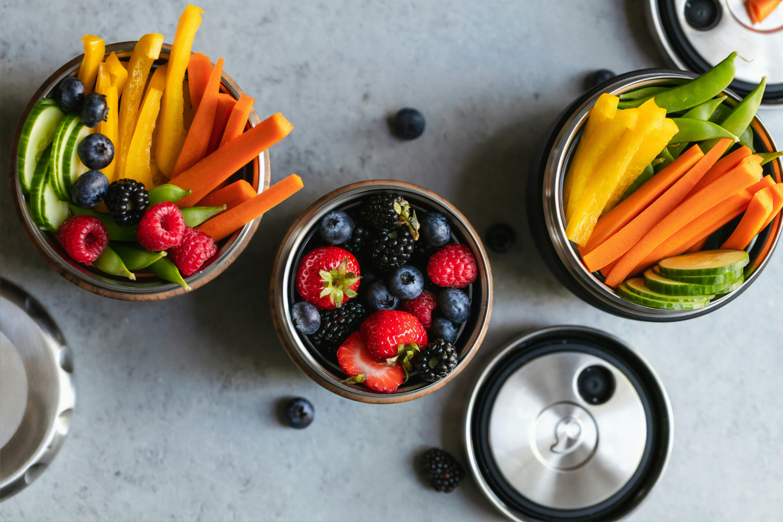 Two cups of sliced orange carrot sticks, yellow bell pepper slices, thinly sliced cucumbers circles and sugar snap peas. One cup of fresh blueberries, blackberries and raspberries. These fresh fruits and vegetables can be part of a healthy and well balanced snack.